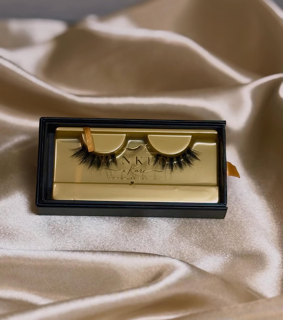 Kiss Me strip lashes in a black and gold Winked x Kari box